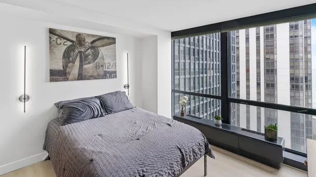 a bedroom with a bed and a large window