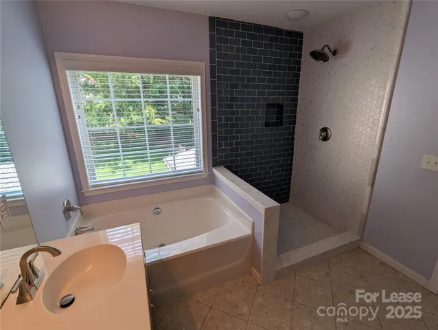 a bathroom with a tub a sink and a window