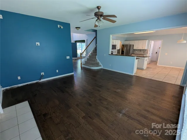 a view of a kitchen with wooden floor and a ceiling fan