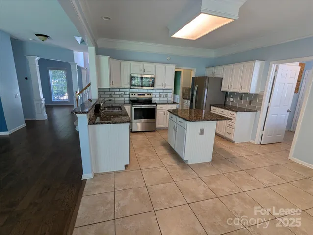 a kitchen with a sink a counter top space cabinets and stainless steel appliances