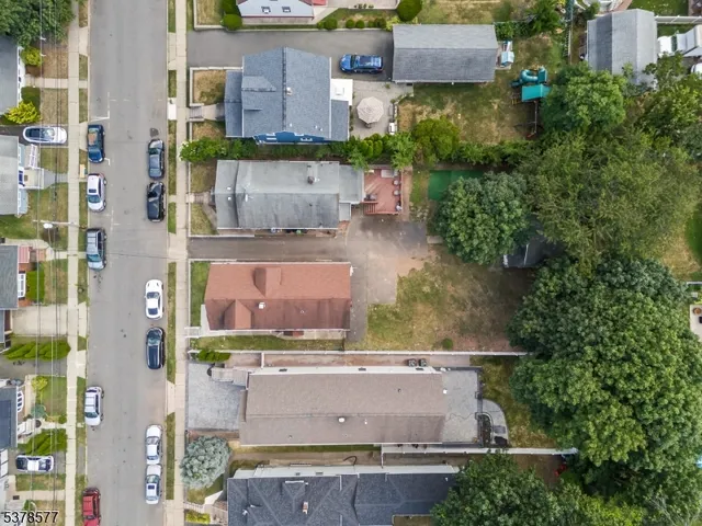 an aerial view of a house with a yard and large tree