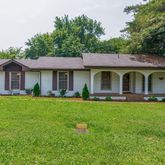 a front view of a house with yard and green space