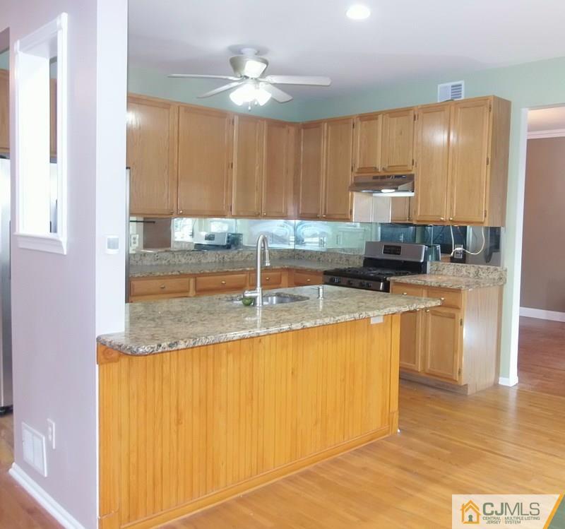 67 Shaffer Road Bridgewater, NJ 08807 - Photo 19 of 25 a kitchen with kitchen island granite countertop a sink cabinets and stainless steel appliances