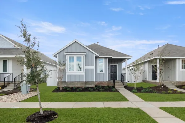 a front view of a house with a garden and yard