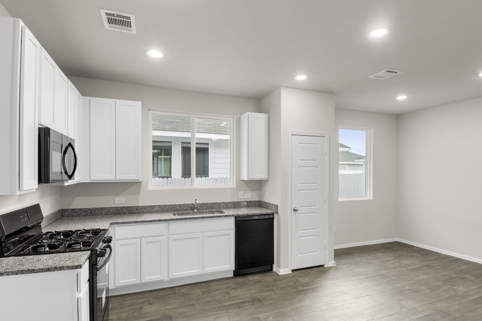 3043 Winding Creek Road Kyle, TX 78640 - Photo 19 of 30 a kitchen that has a lot of cabinets in it and wooden floors
