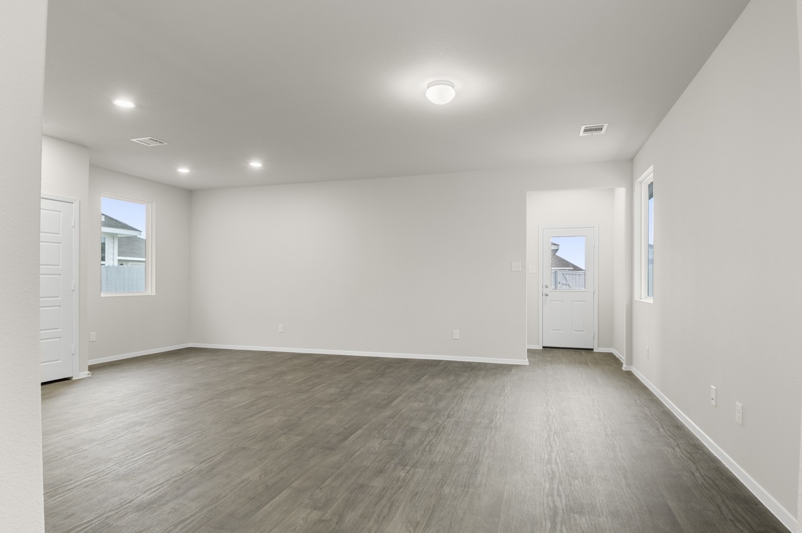 3043 Winding Creek Road Kyle, TX 78640 - Photo 5 of 30 an empty room with wooden floor and windows