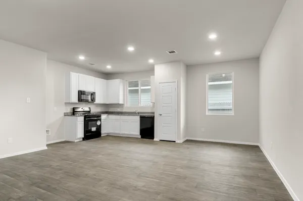 a large kitchen with a large counter top space stainless steel appliances and cabinets