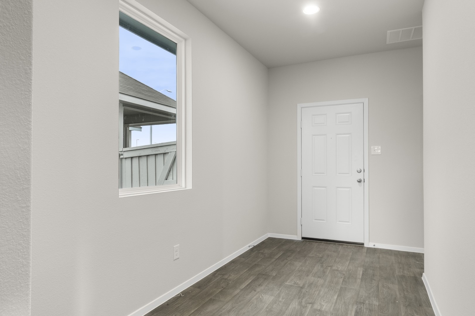 3043 Winding Creek Road Kyle, TX 78640 - Photo 9 of 30 a view of an empty room with wooden floor and windows