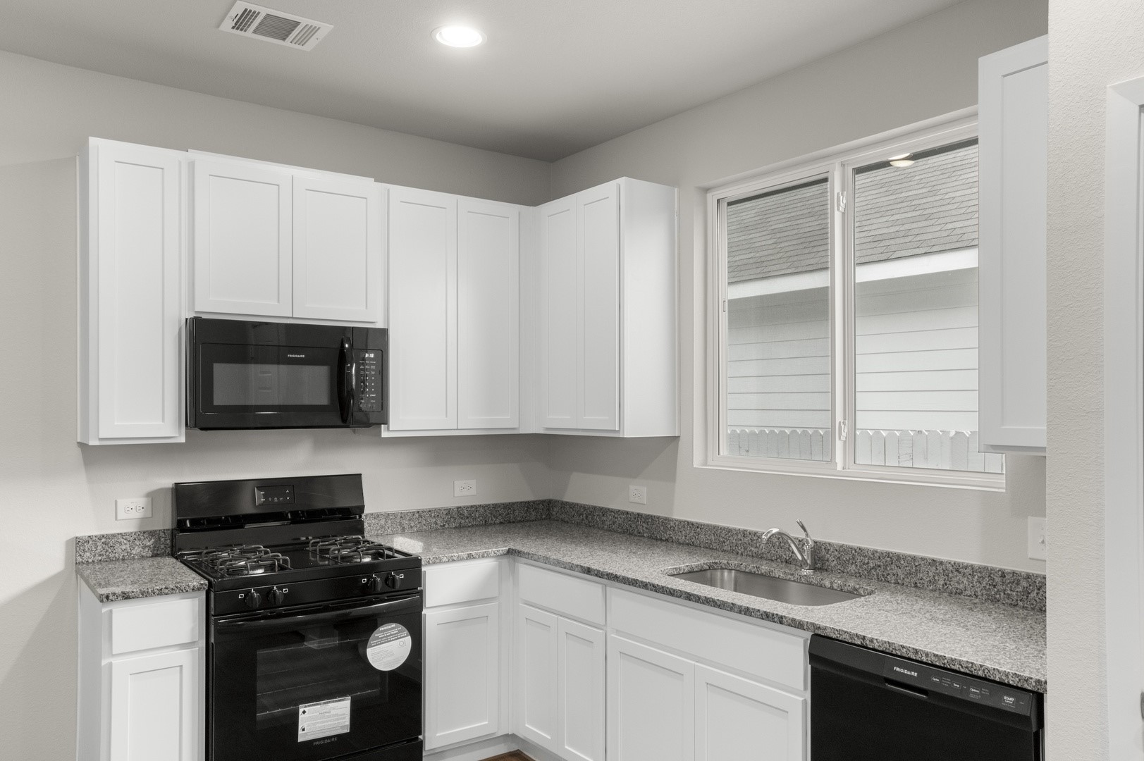 3043 Winding Creek Road Kyle, TX 78640 - Photo 10 of 30 a kitchen with granite countertop white cabinets and black appliances