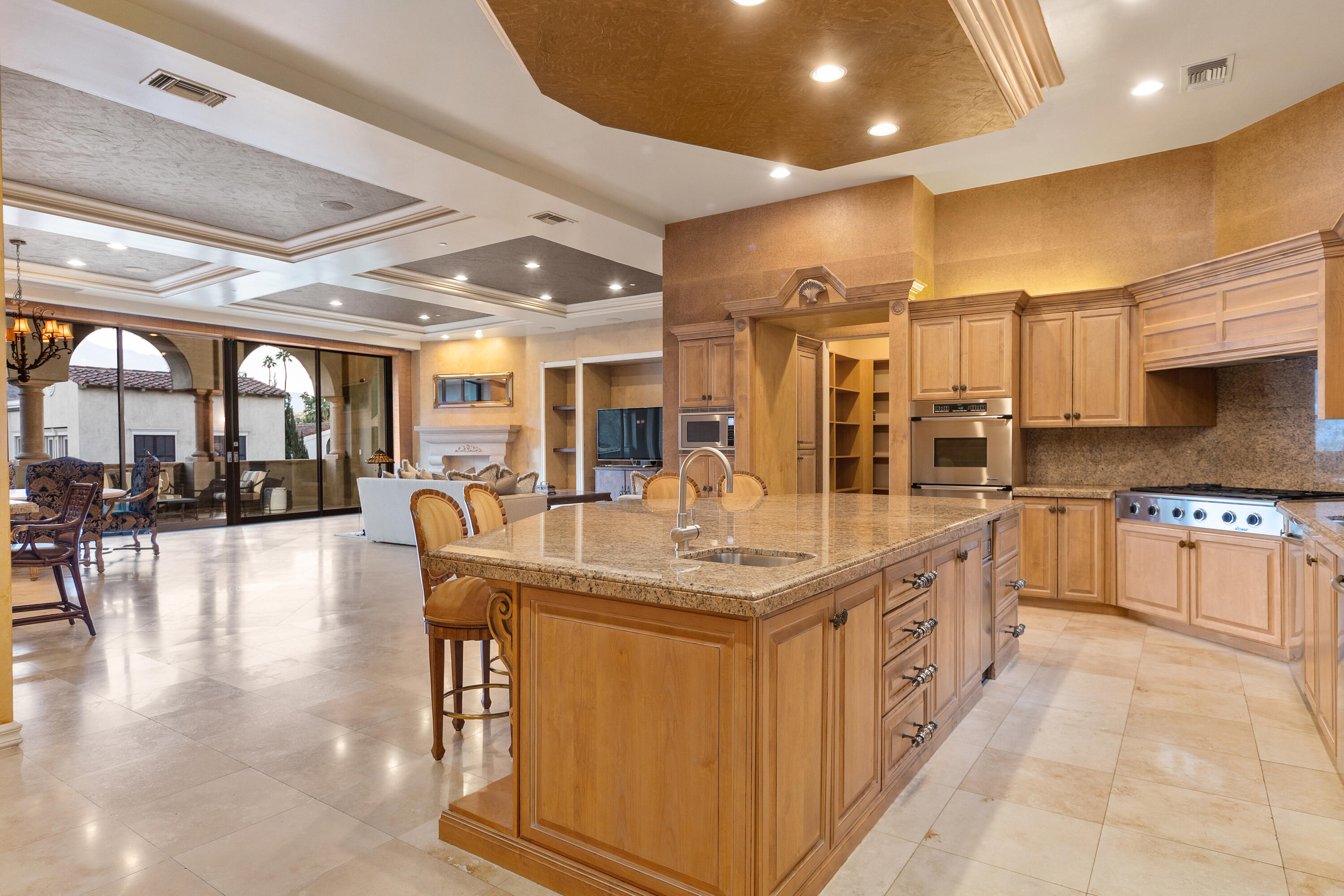 217 Via Veneto Rancho Mirage, CA 92270 - Photo 3 of 66 a large kitchen with stainless steel appliances a large counter top a stove and a refrigerator