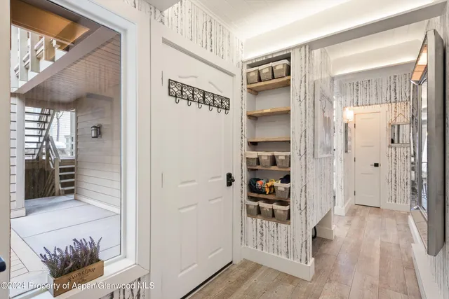 a view of a hallway with wooden floor and entryway