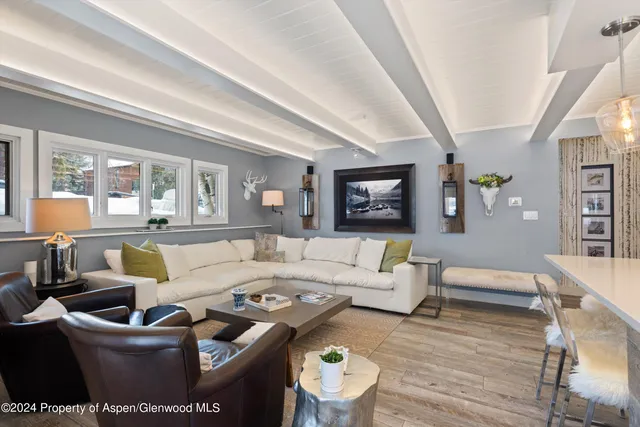 a living room with furniture wooden floor and a large window
