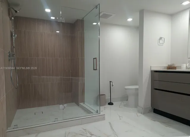 a large kitchen with stainless steel appliances a large counter top