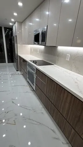 a kitchen with stainless steel appliances granite countertop a sink and a stove