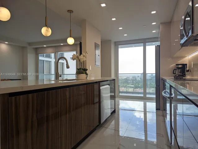 a large kitchen with a large counter top stainless steel appliances and a counter top space