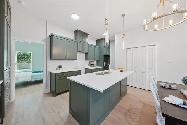 a large kitchen with a stove a sink dishwasher and a refrigerator with wooden floor