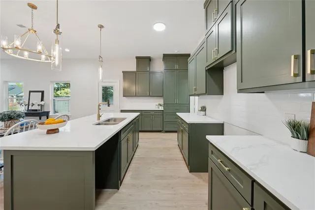 a kitchen with stainless steel appliances a sink a counter top space cabinets and wooden floor