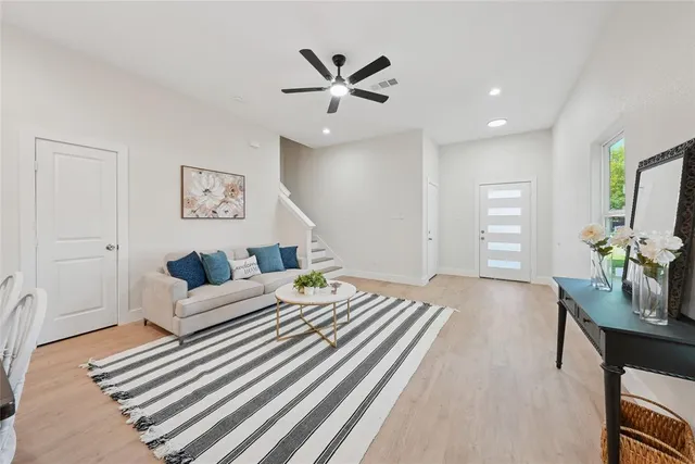 a living room with furniture and a ceiling fan