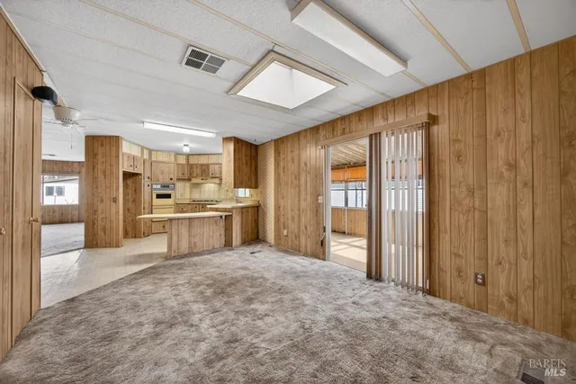 a large white kitchen with a refrigerator a sink dishwasher and cabinets