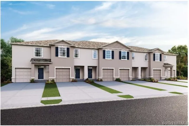 a view of a house with a small yard and large trees
