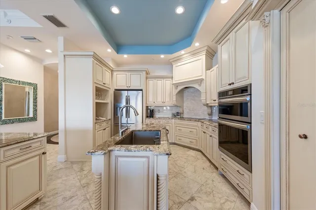 a kitchen with stainless steel appliances granite countertop a stove a refrigerator a sink a dining table and chairs with wooden floor