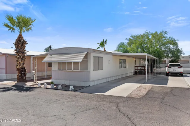 a front view of a house with a yard and potted plants