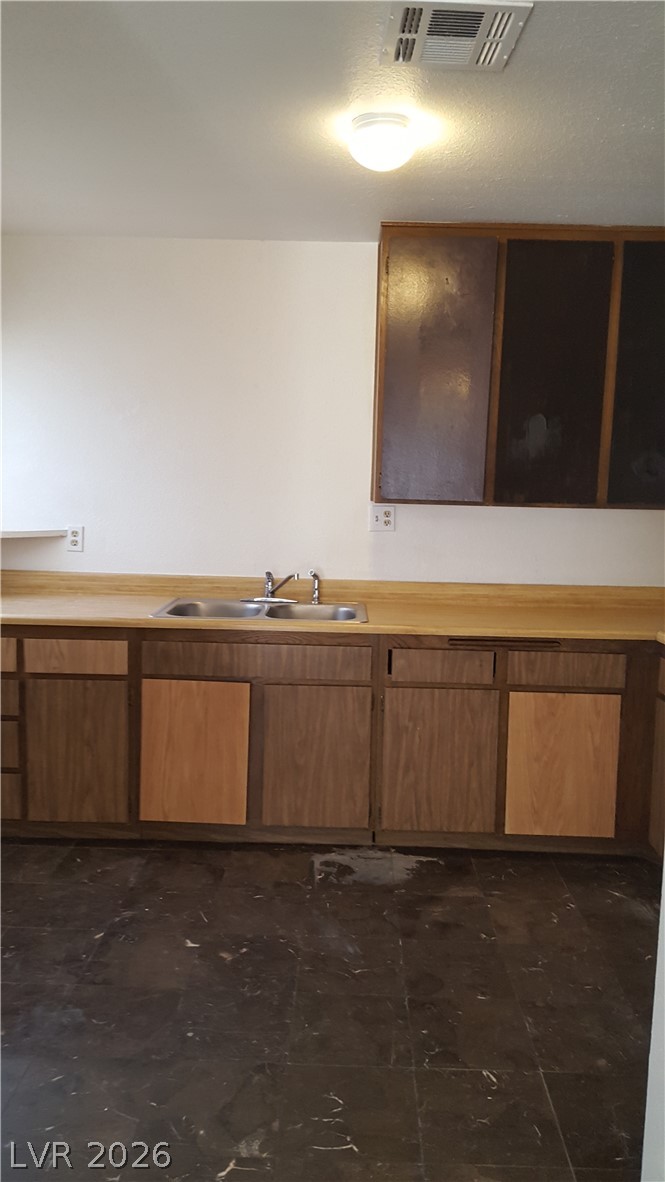 6433 Addely Drive Las Vegas, NV 89108 - Photo 12 of 27 Kitchen featuring light countertops and wood finish cabinetry