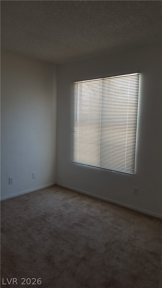 6433 Addely Drive Las Vegas, NV 89108 - Photo 20 of 27 Unfurnished room featuring a textured ceiling and dark carpet