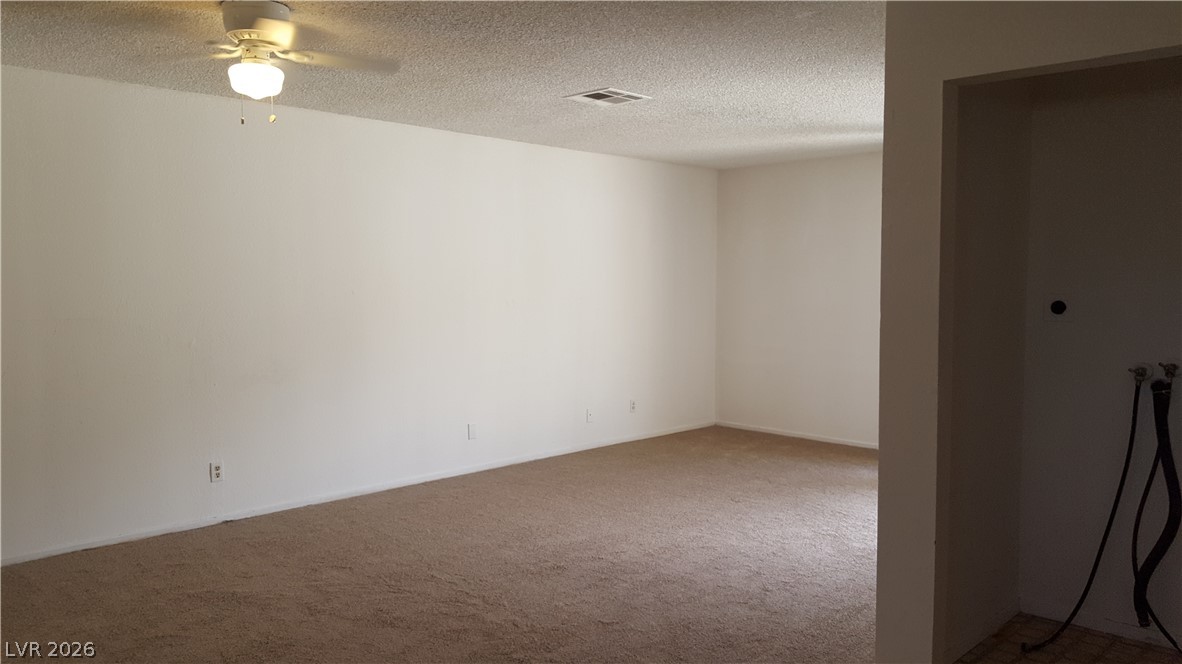 6433 Addely Drive Las Vegas, NV 89108 - Photo 5 of 27 Carpeted spare room featuring a ceiling fan and a textured ceiling