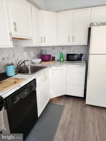 a kitchen with stainless steel appliances white cabinets sink and a granite counter top