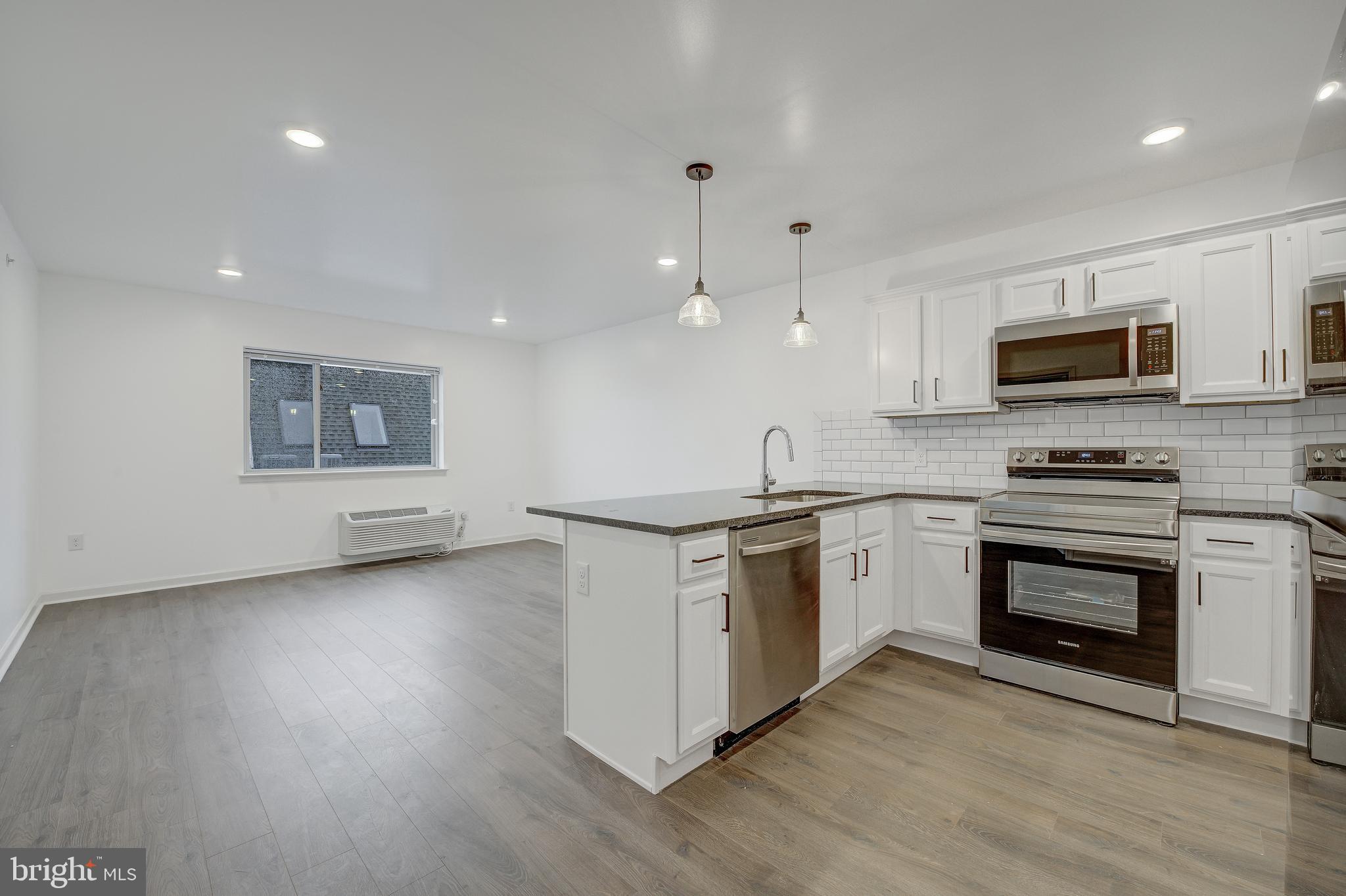 6649 Ridge Avenue, Unit C206 Philadelphia, PA 19128 - Photo 2 of 10 a kitchen with granite countertop a stove top oven and a sink