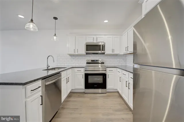a kitchen with white cabinets and stainless steel appliances