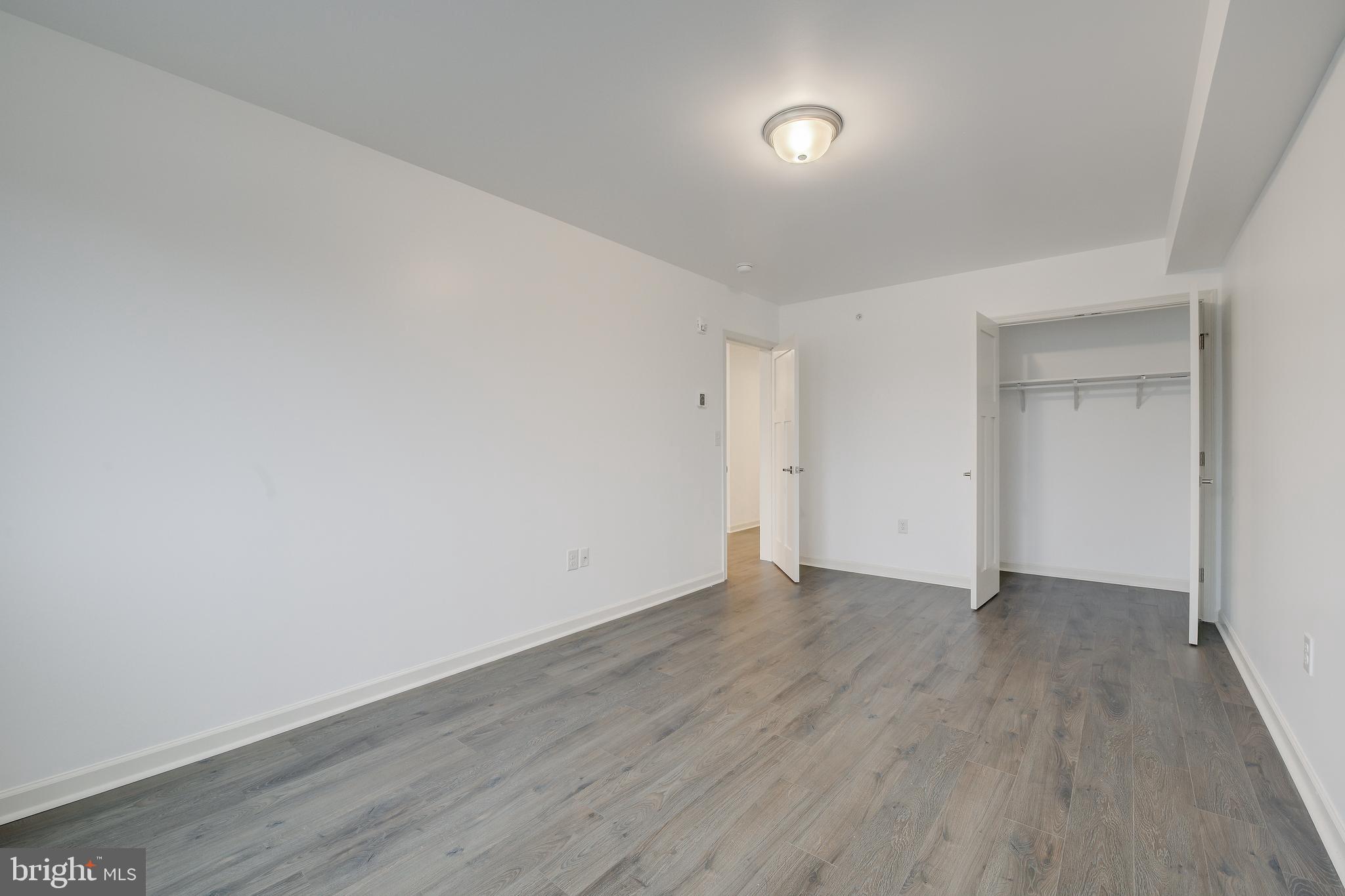 6649 Ridge Avenue, Unit C206 Philadelphia, PA 19128 - Photo 9 of 10 a view of an empty room with wooden floor and a window