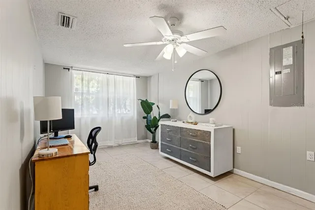 a living room with furniture a mirror and a fan
