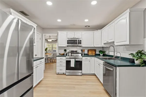 a kitchen with stainless steel appliances granite countertop a refrigerator a stove top oven a sink and dishwasher