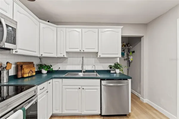 a kitchen with granite countertop white cabinets and white appliances