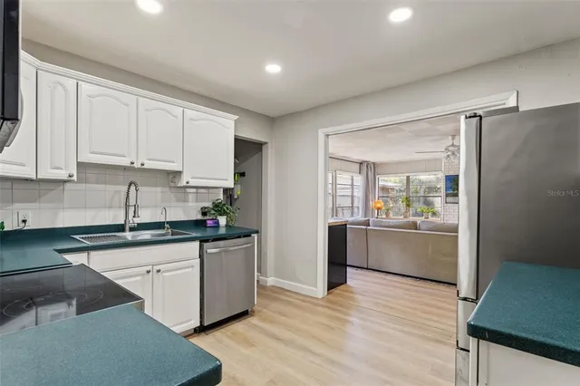 a kitchen with granite countertop a refrigerator and a stove top oven