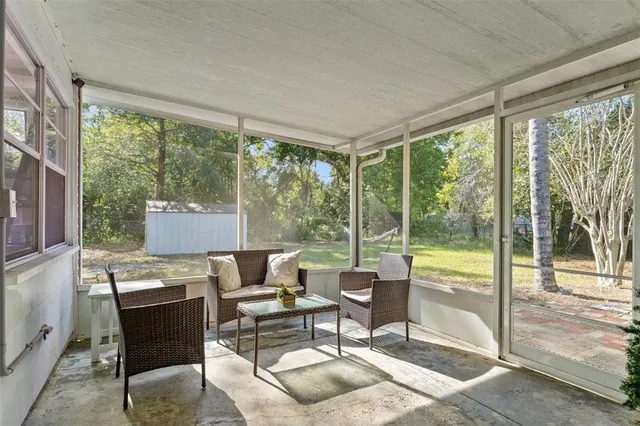 a living room with furniture and a floor to ceiling window