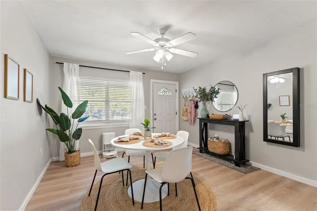 a dining room with furniture potted plants and wooden floor
