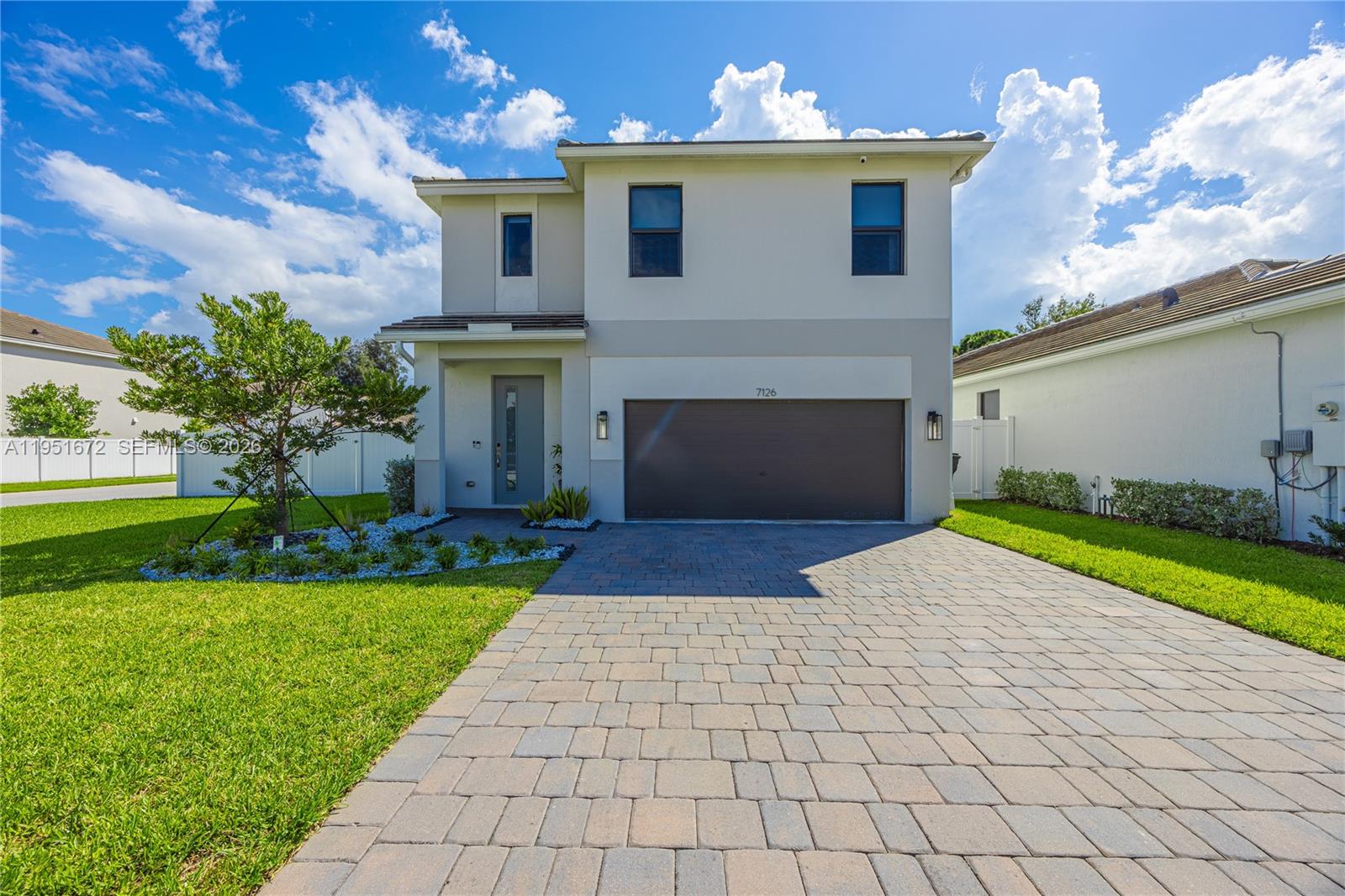 7126 Rockwood Road Jupiter, FL 33458 - Photo 2 of 35 a front view of a house with a yard and a garage