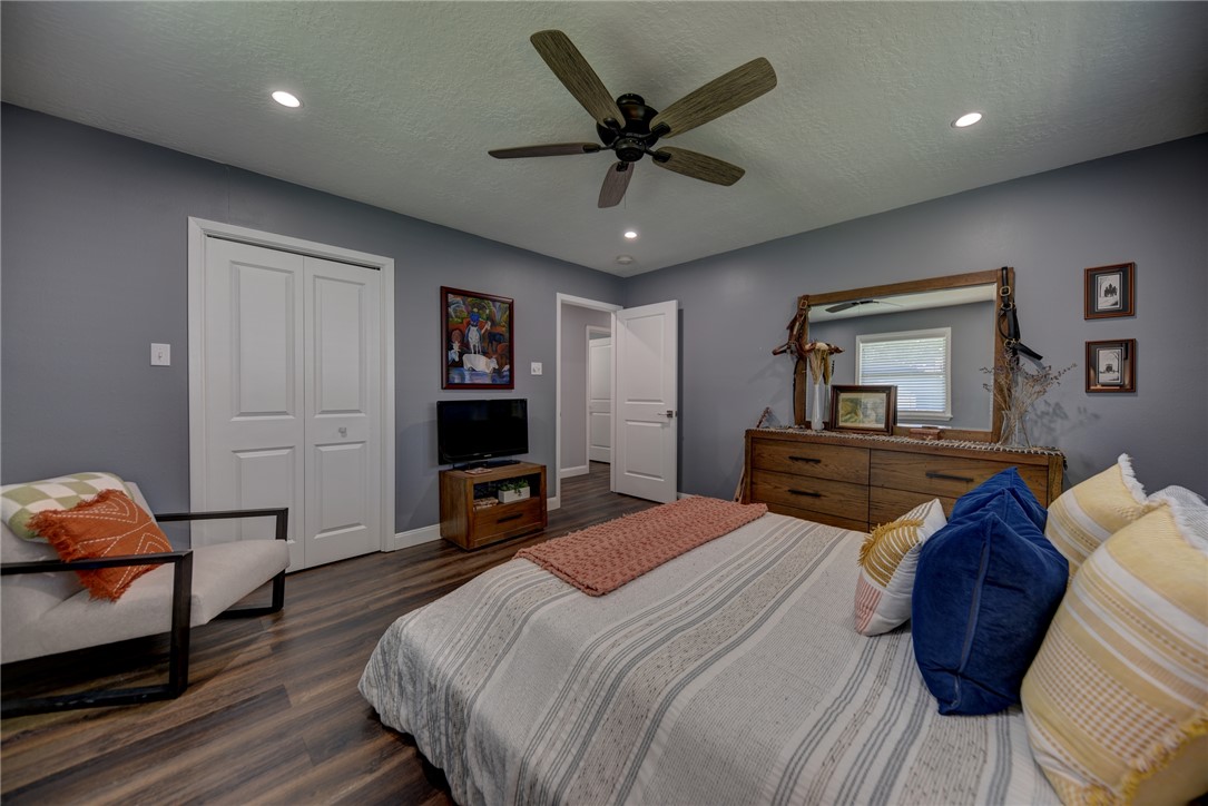 1600 Pecan Street Brenham, TX 77833 - Photo 14 of 33 Bedroom with dark wood-style flooring, a textured ceiling, a walk-in closet, recessed lighting and ceiling fan