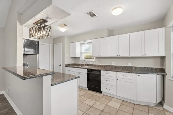 a kitchen with granite countertop white cabinets and white appliances
