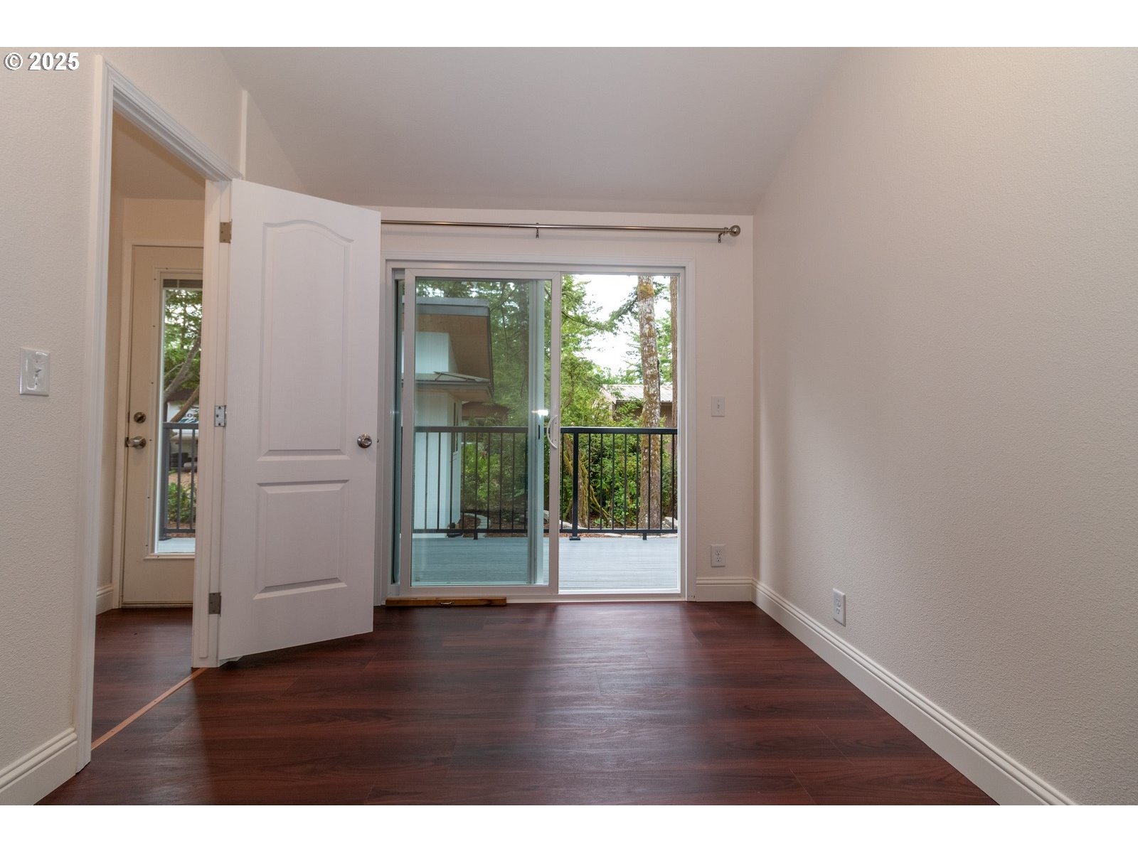 231 Horseshoe Bend Florence, OR 97439 - Photo 11 of 26 a view of an empty room with wooden floor and a window
