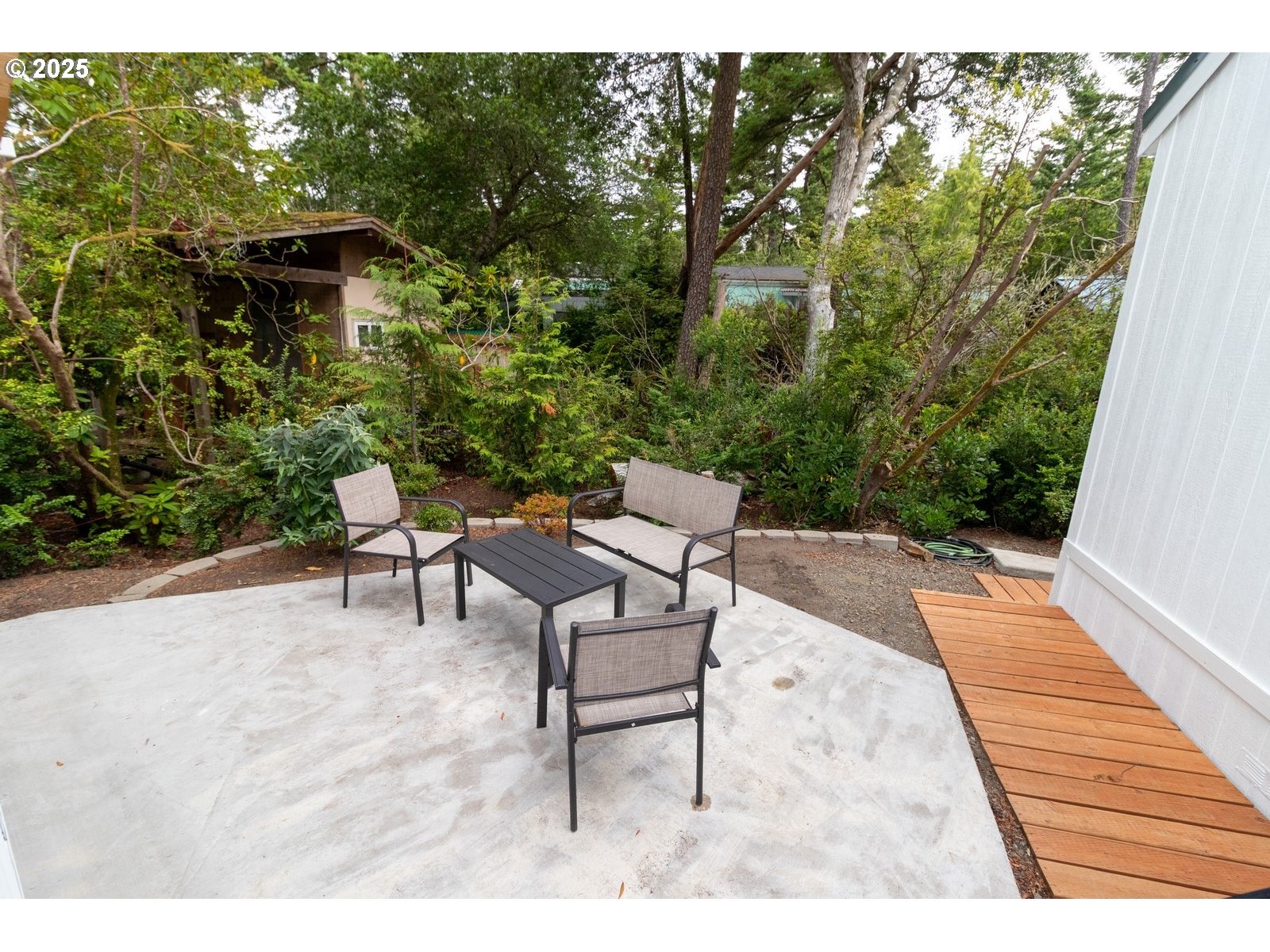 231 Horseshoe Bend Florence, OR 97439 - Photo 24 of 26 a backyard of a house with table and chairs