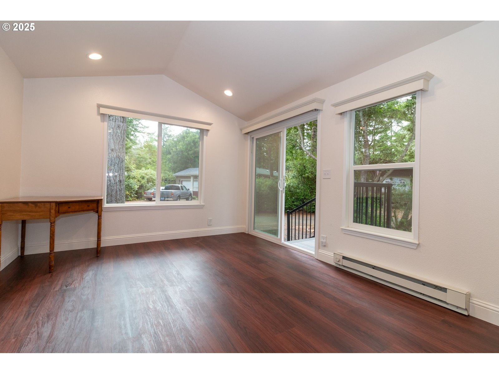231 Horseshoe Bend Florence, OR 97439 - Photo 7 of 26 a view of an empty room with wooden floor and a window