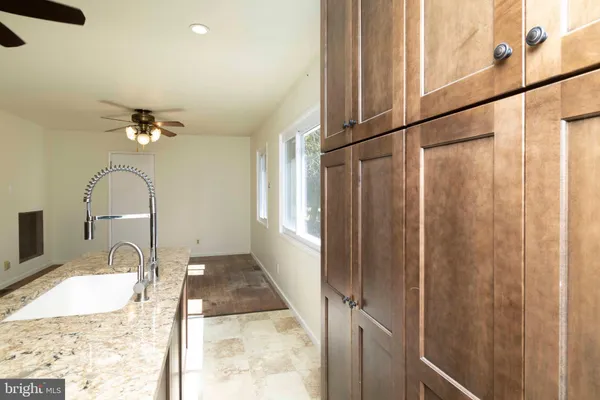 a bathroom with a granite countertop sink a mirror and shower