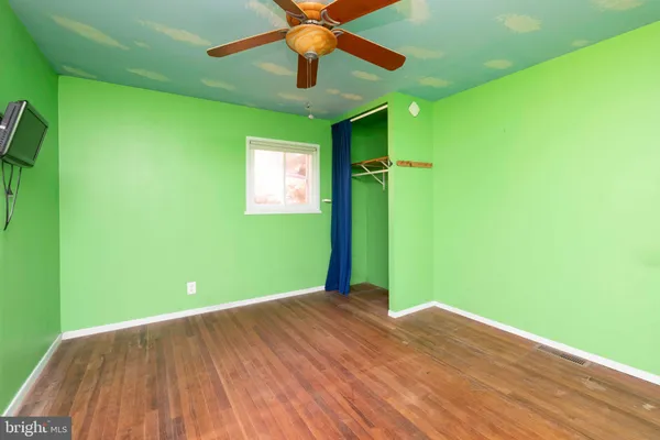 a view of empty room with ceiling fan and window