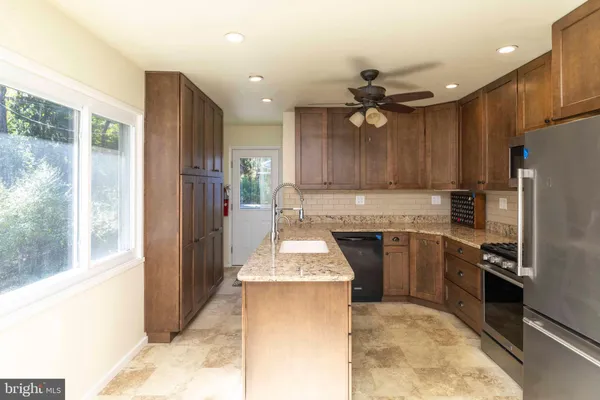 a kitchen with kitchen island granite countertop a stove refrigerator and cabinets
