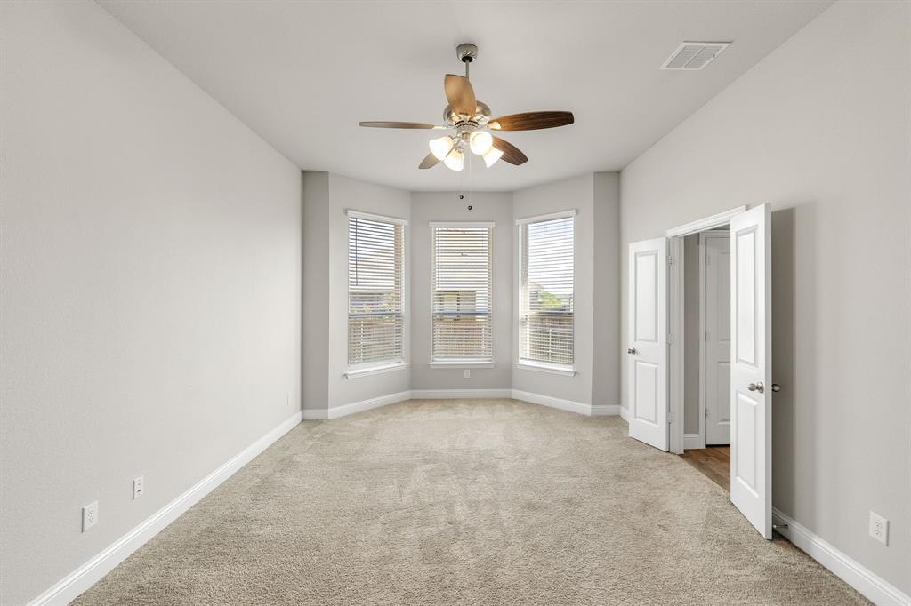 915 Timber Ridge Drive Justin, TX 76247 - Photo 19 of 39 Spacious room featuring a bay window, ceiling fan with integrated lighting, neutral-toned carpeting, and crisp white trim
