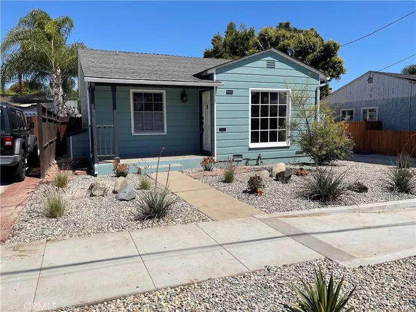 a view of house with yard and sitting area